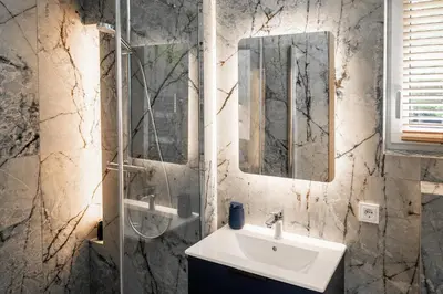 a bathroom with a sink and a glass shower at Nemunas Glamping in Kriemala