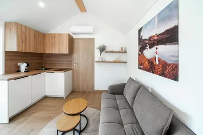 a living room with a couch and a table at Nemunas Glamping in Kriemala