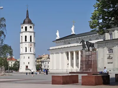a building with a clock tower and a statue in front of it at 2 Bedrooms Apartment Vilnius Center in Vilnius