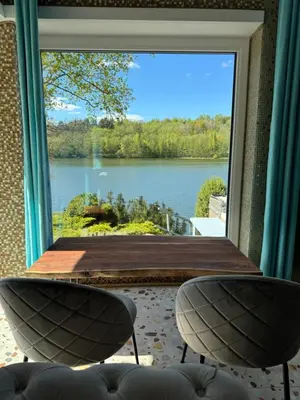 a room with a large window with a view of a lake at Dream Vila Trakai in Trakai