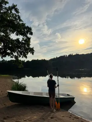 a woman is standing in a boat on a lake at Dream Vila Trakai in Trakai