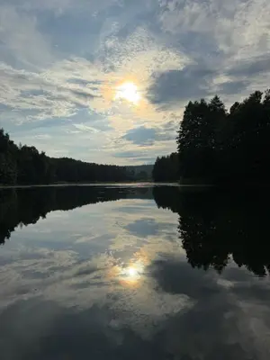 a lake with the reflection of the sun in the water at Dream Vila Trakai in Trakai