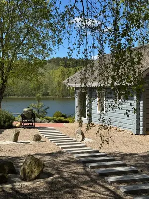 a white building with stairs next to a lake at Dream Vila Trakai in Trakai