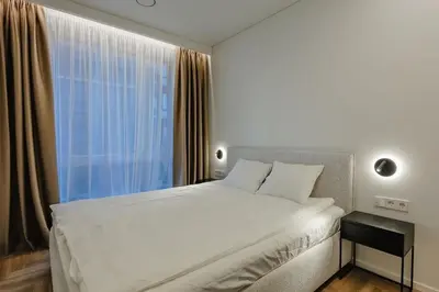 a bedroom with a large white bed and a window at Nemunaičiai Relax in Kaunas