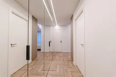 a hallway with white doors and a wooden floor at Nemunaičiai Relax in Kaunas