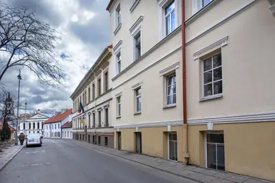 a building on a street with a car parked next to it at Apartments in the old town in Vilnius