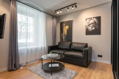 a living room with a leather couch and a table at Apartments in the old town in Vilnius