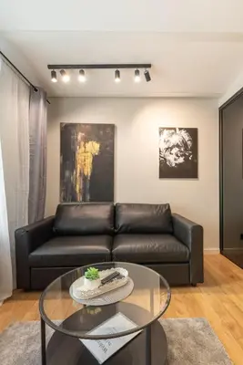 a living room with a leather couch and a glass table at Apartments in the old town in Vilnius