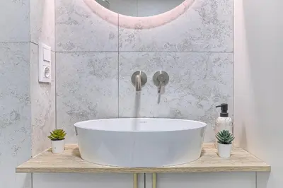 a white bath tub sitting on a counter in a bathroom at Sunny loft 2 x 24x7 x Free parking x Close to old town in Vilnius