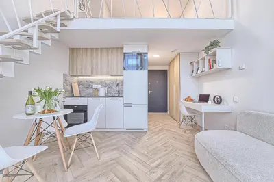 a kitchen and living room with a couch and a table at Sunny loft 2 x 24x7 x Free parking x Close to old town in Vilnius