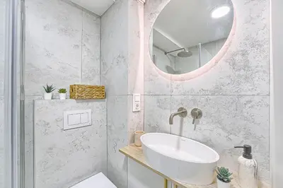 a bathroom with a sink and a mirror at Sunny loft 2 x 24x7 x Free parking x Close to old town in Vilnius