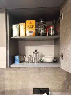 a kitchen shelf with plates and other items on it at Happy Inn VIP Lounge, self check-in, parking in Vilnius