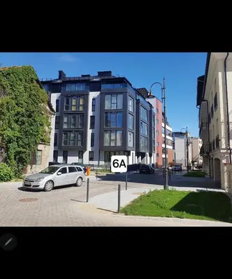 a car parked in a parking lot in front of a building at Happy Inn VIP Lounge, self check-in, parking in Vilnius