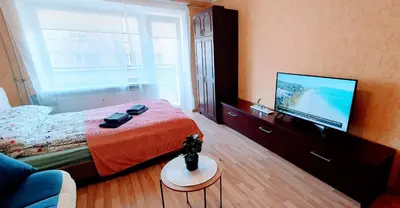 a bedroom with a bed and a flat screen tv at SUN CITY Varpo Apartment in Šiauliai