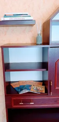 a wooden shelf with books on top of it at SUN CITY Varpo Apartment in Šiauliai