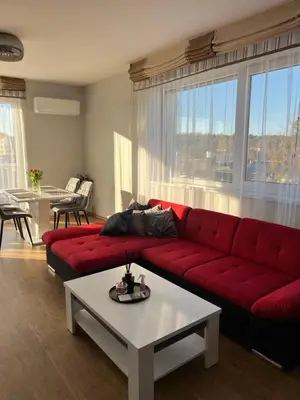 a living room with a red couch and a table at Holiday Home in Druskininkai