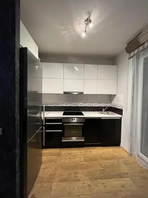 a kitchen with white cabinets and a stainless steel refrigerator at Holiday Home in Druskininkai
