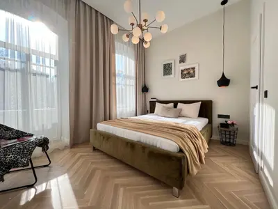 a bedroom with a bed and a chandelier at City central apartment in Vilnius
