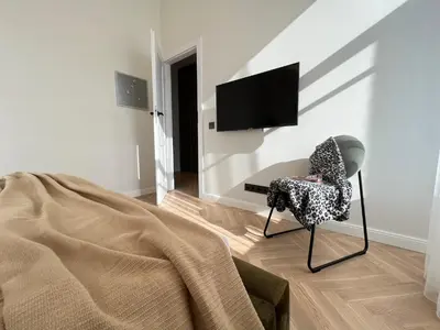 a living room with a chair and a television at City central apartment in Vilnius