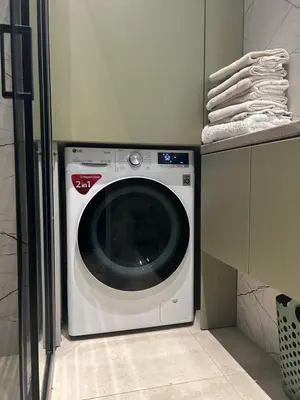a washing machine in a kitchen next to a cabinet at City central apartment in Vilnius