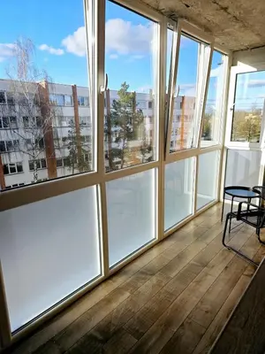 a room with large windows with a table and chairs at Cozy Corner in Šiauliai