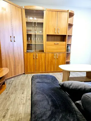 a living room with wooden cabinets and a table at Cozy Corner in Šiauliai