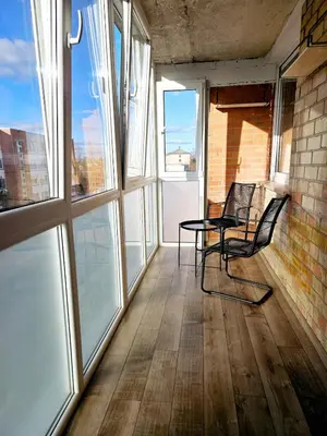 a balcony with a table and chairs and windows at Cozy Corner in Šiauliai