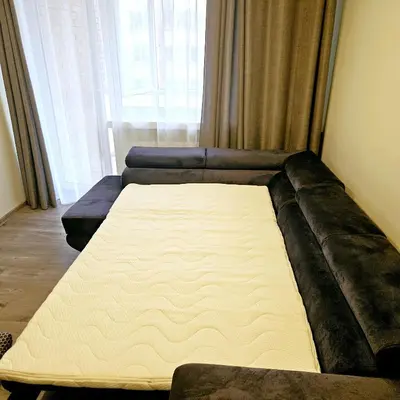 a mattress on a couch in a room with a window at Cozy Corner in Šiauliai