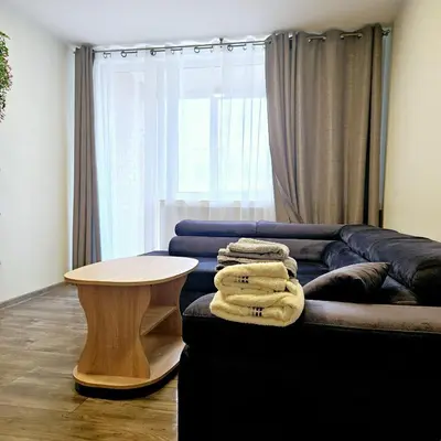 a living room with a couch and a table at Cozy Corner in Šiauliai
