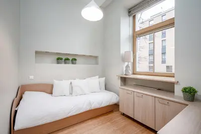 a small bedroom with a bed and a window at Cozy 2-Bedroom Apartment - 4 in Vilnius