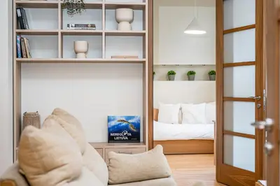 a living room with a couch and a bedroom at Cozy 2-Bedroom Apartment - 4 in Vilnius