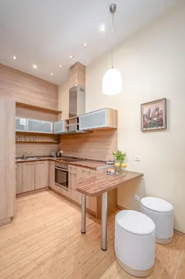 a kitchen with a wooden table and two stools at Cozy 2-Bedroom Apartment - 4 in Vilnius