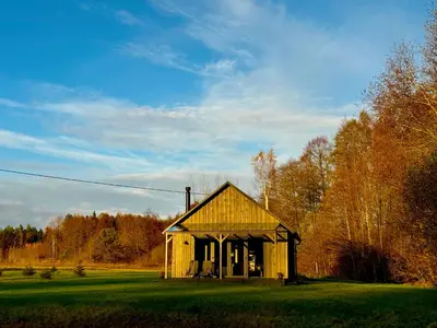 an old barn in the middle of a field at MOSS lodge in Naujasėdžiai
