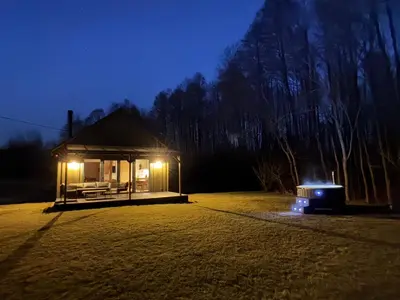 a small building with lights in a field at night at MOSS lodge in Naujasėdžiai