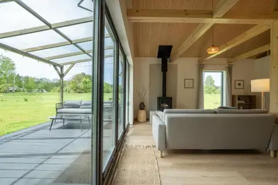 a living room with glass doors and couches at MOSS lodge in Naujasėdžiai