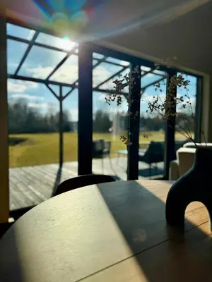 a table and chairs in front of a large window at MOSS lodge in Naujasėdžiai