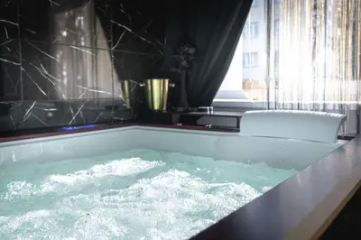 a bath tub filled with water in a bathroom at Euforia - Jacuzzi apartment Ukmergė in Ukmergė