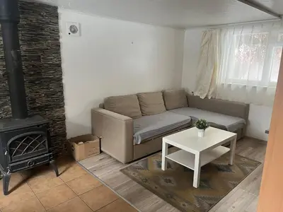 a living room with a couch and a stove at Small house in Vilnius
