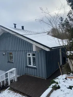 a small blue house with a snow covered roof at Small house in Vilnius