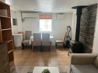 a living room with a table and chairs and a stove at Small house in Vilnius