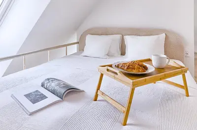 a bed with a table with a plate of food on it at Amazing apartments 2 x free parking x 24x7 in Vilnius