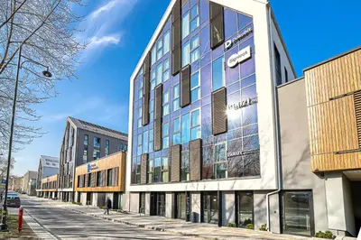 a building with glass windows on a city street at Amazing apartments 2 x free parking x 24x7 in Vilnius