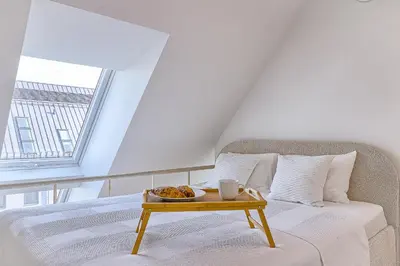a bed with a tray of food on a table at Amazing apartments 2 x free parking x 24x7 in Vilnius