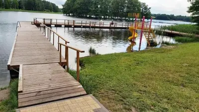 a wooden dock with a playground on a lake at Kambarių nuoma prie Bridvaišio ežero in Tytuvėnai