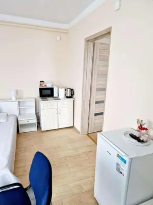 a kitchen with a white refrigerator and a blue chair at Kambarių nuoma prie Bridvaišio ežero in Tytuvėnai