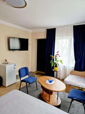 a hotel room with a bed and a table and chairs at Kambarių nuoma prie Bridvaišio ežero in Tytuvėnai
