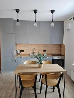 a kitchen with a wooden table and chairs at Vilniaus apartamentai in Vilnius
