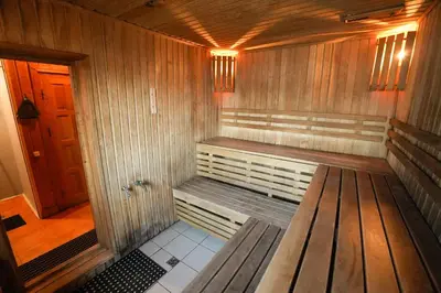 a wooden sauna with a bench in a room at 6 vietų namelis ant ežero kranto in Sudervė