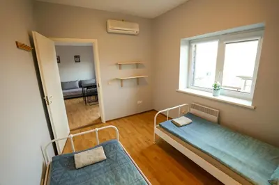 a small room with two beds and a window at 6 vietų namelis ant ežero kranto in Sudervė