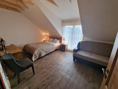 a bedroom with a bed and a couch and a chair at Roksala in Taručiai
